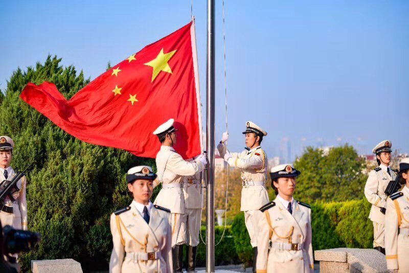 上午7时整,青岛大学国旗护卫队护送国旗入场,现场千余名师生庄严肃立